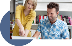 Two technology professionals stand behind a computer, discussing their content strategy.