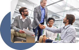 A sales team meets with a client. Two leaders are shaking hands, signifying a sales deal.