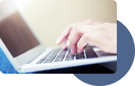 Side view of hands typing on a laptop computer.